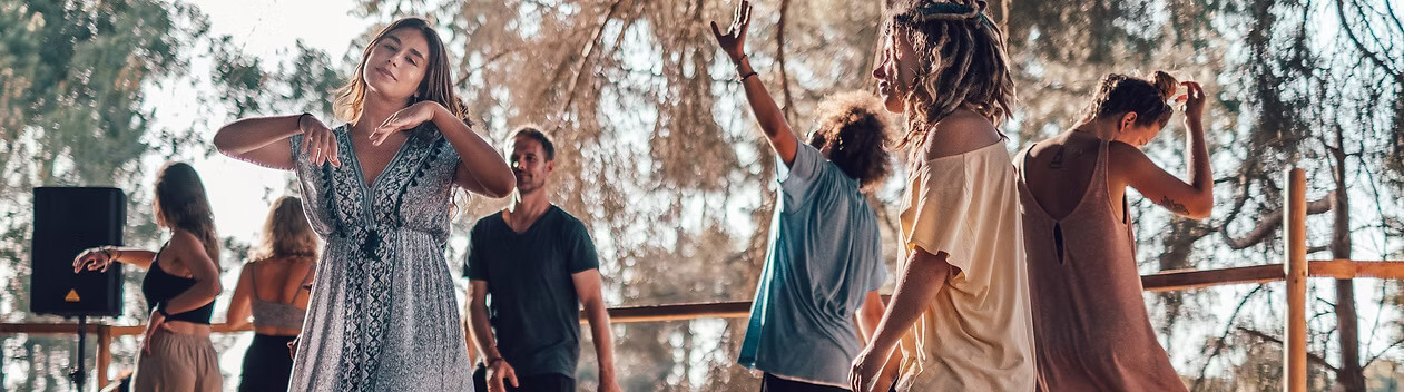 People gathering at a bright outdoor deck for an conscious ecstatic dance session in Lagos, Portugal.